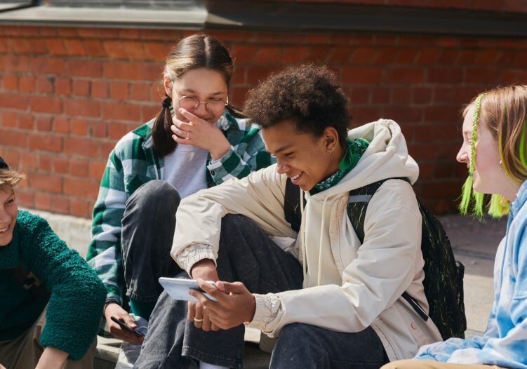 Group of friends sitting together using their phones